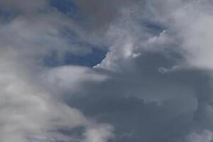 Cloudscape scenery, overcast weather above dark blue sky. Storm clouds floating in a rainy dull day with natural light. White and grey scenic environment background. Nature view. photo