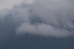 Cloudscape scenery, overcast weather above dark blue sky. Storm clouds floating in a rainy dull day with natural light. White and grey scenic environment background. Nature view. photo