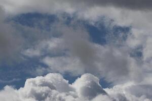 Cloudscape scenery, overcast weather above dark blue sky. Storm clouds floating in a rainy dull day with natural light. White and grey scenic environment background. Nature view. photo