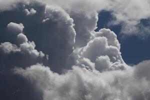 Cloudscape scenery, overcast weather above dark blue sky. Storm clouds floating in a rainy dull day with natural light. White and grey scenic environment background. Nature view. photo