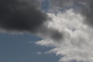 Cloudscape scenery, overcast weather above dark blue sky. Storm clouds floating in a rainy dull day with natural light. White and grey scenic environment background. Nature view. photo