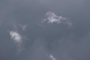 Cloudscape scenery, overcast weather above dark blue sky. Storm clouds floating in a rainy dull day with natural light. White and grey scenic environment background. Nature view. photo