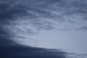 Cloudscape scenery, overcast weather above dark blue sky. Storm clouds floating in a rainy dull day with natural light. White and grey scenic environment background. Nature view. photo