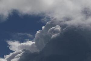 Cloudscape scenery, overcast weather above dark blue sky. Storm clouds floating in a rainy dull day with natural light. White and grey scenic environment background. Nature view. photo