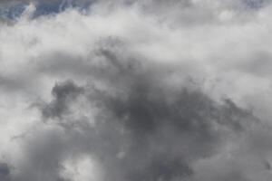 Cloudscape scenery, overcast weather above dark blue sky. Storm clouds floating in a rainy dull day with natural light. White and grey scenic environment background. Nature view. photo