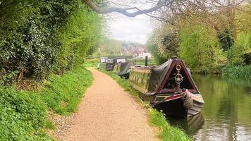 Scenic view of canal boat and picturesque waterway, surrounded by lush greenery and quaint countryside in Apsley, Hertfordshire, England, United Kingdom video