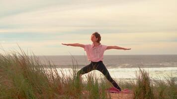 Yoga exercises with autumn windy weather and ocean sunset background video