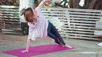 reifen Frau trainieren Yoga Asanas Seite Planke Pose draußen auf Natur video