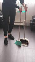 Barber sweeping hair clippings with broom and scoop after giving haircut video