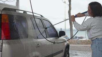 mulher lavando carro com Alto pressão água equipamento bomba video