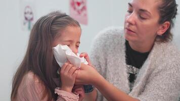 Caring mother spraying nasal spray into nose of ill daughter at home video