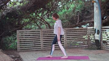 Woman do yoga in pine forest on wooden floor video