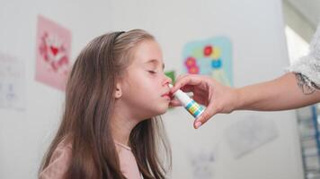 Caring mother spraying nasal spray into nose of sick daughter at home video