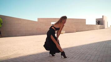 Woman in black dress dancing gracefully in wind in city video