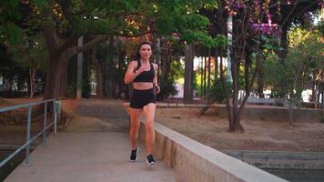 Determined woman runner jogging in city park video