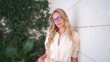 Smiling blond woman adjusting smart eyeglasses outside building video