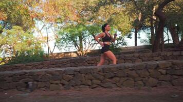 Active woman in sportswear jogging in summer park video