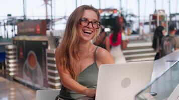 alegre fêmea trabalhador autonomo usando computador portátil dentro café fazer compras video