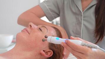 esthéticien masser visage de femme avec spécial outil dans beauté spa video