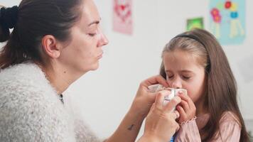 Mother cleaning and emptying daughter's nose with nasal spray video