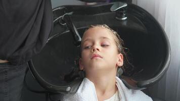 menina tendo dela cabelo lavado com xampu dentro salão video