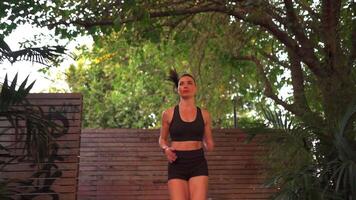 Athletic woman in activewear jogging in park video