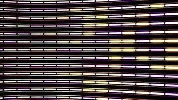 Horizontal flow of abstract neon lines of purple and yellow colors with camera lens distort on black background. Animation. Narrow stripes devided into segments, seamless loop. video