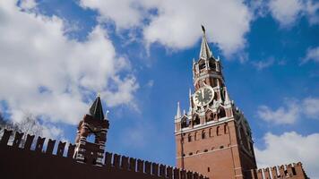 röd kreml fästning och spasskaya torn på bakgrund av blå himmel. handling. topp av röd fästning vägg och kreml klocka torn video