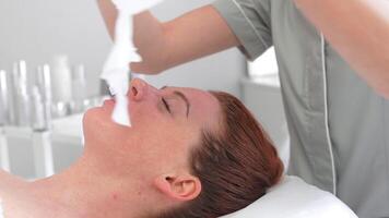 cosmétologue en mettant feuille masque sur visage de femme relaxant à beauté spa video