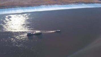 Winter bird's-eye view. Clip. Cargo ships moving along the river and carrying cargo . video