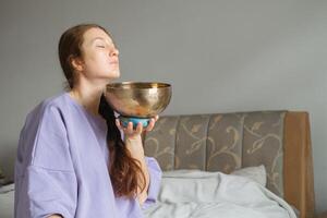 mujer abrazando sonido curación con canto cuenco foto