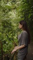 fille permanent dans le milieu de jungle et forêt tropicale sur une chemin, verticale video