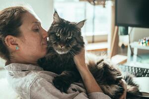 mujer abrazando su Maine mapache gato foto