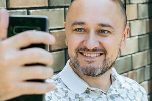 alegre hombre tomando selfie al aire libre foto