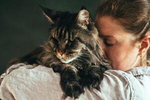 mujer abrazando mascota gato a hogar foto