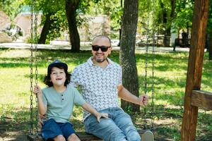 padre y hijo disfrutando columpio hora foto