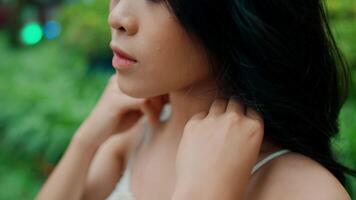 Close-up of a thoughtful woman with a serene expression, set against a soft-focus green background. video