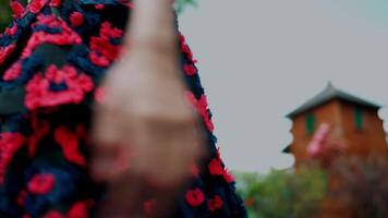 Woman in a floral dress standing on a vibrant green textured surface. video