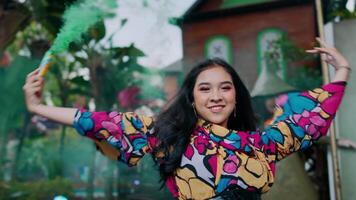Smiling young woman in colorful blouse posing outdoors with an urban backdrop. video