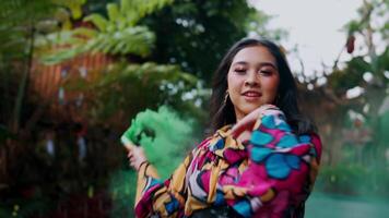 Confident woman in colorful dress walking outdoors with greenery in the background. video