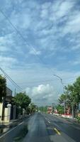 de banlieue tranquillité une silencieux route voyage décoré avec bleu ciels et peu des nuages. joindre une paisible conduire par le serein de banlieue des rues, en dessous de une ciel peint avec des nuages. video