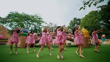borroso movimiento de un grupo de bailarines en rosado vestidos ejecutando al aire libre, transporte energía y movimienot. video
