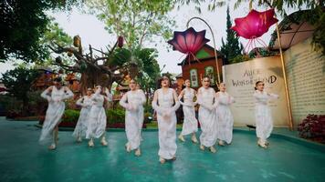Group of dancers performing outdoors in a whimsical garden setting. video