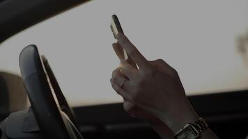 Hand using phone in car at sunset in summer, travel concept video