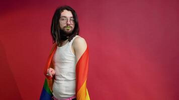 Man transgender holding rainbow flag LGBT on red background. Gay pride concept. Vote for homosexual love video