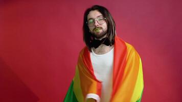 uomo Tenere arcobaleno bandiera lgbt su rosso sfondo. gay orgoglio concetto. votazione per omosessuale amore video