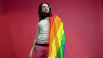 Man transgender holding rainbow flag LGBT on red background. Gay pride concept. Vote for homosexual love video