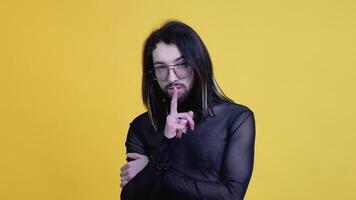 Young smiling happy cheerrful gay man in glasses and mesh t-shirt isolated on yellow color background. Lifestyle lgbtq pride concept video