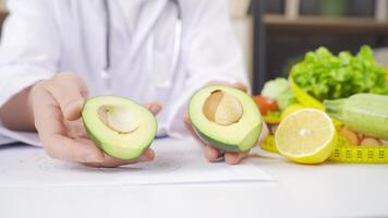 Ernährungsberater spalten ein Avocado im Hälfte. video