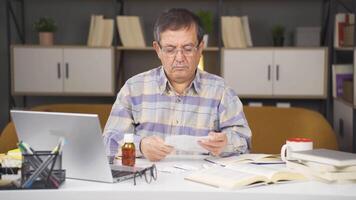 antiguo hombre tomando medicina es leyendo el paquete insertar. video